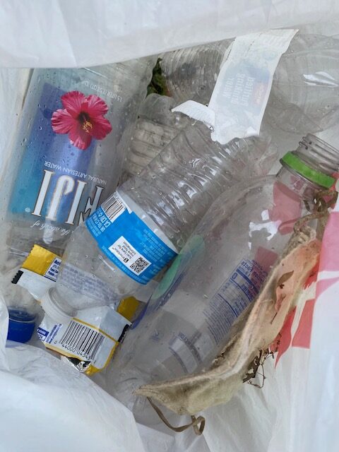 A plastic bag filled with trash found along the trail